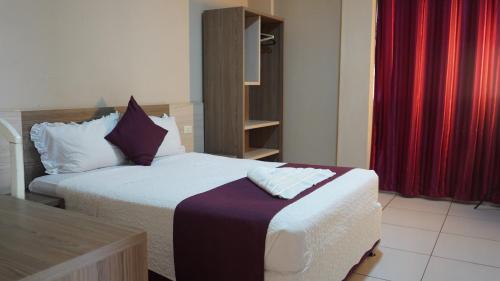 a hotel room with two beds and a table at Hotel Ciudad Nueva in Ciudad del Este