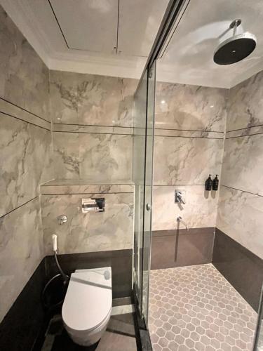 a bathroom with a toilet and a glass shower at The Koi Boutique Hotel in Gurgaon