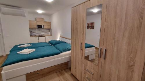 a small bedroom with a bed with a wooden door at Apartment and Studios Jelovca & Wellness in Radovljica