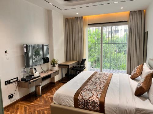 a hotel room with a bed and a desk and a window at The Koi Boutique Hotel in Gurgaon