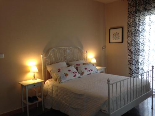 a bedroom with a white bed with pillows and two lamps at Affittacamere Le Rose in Imola