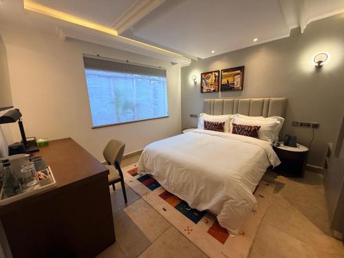 a bedroom with a bed and a desk and a window at Yeza Garden Hotel in Nairobi