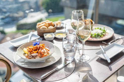 a table with plates of food and glasses of wine at Hotel Dom Henrique - Downtown in Porto