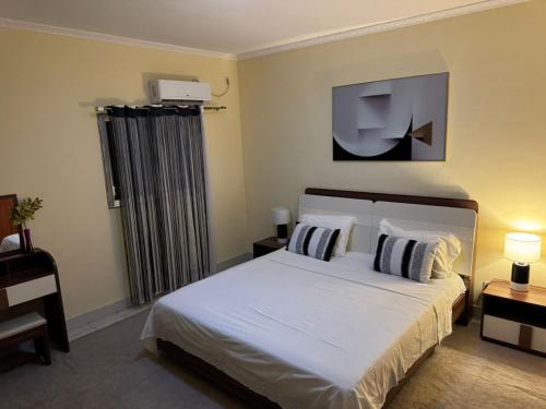 a bedroom with a bed and a tv on the wall at Espaço Acolhedor in Luanda