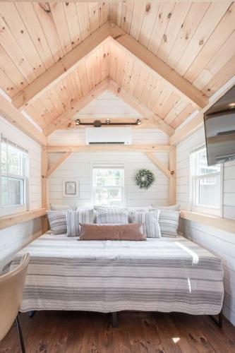 a large bed in a room with a wooden ceiling at Creekside Village Inn in Spearfish