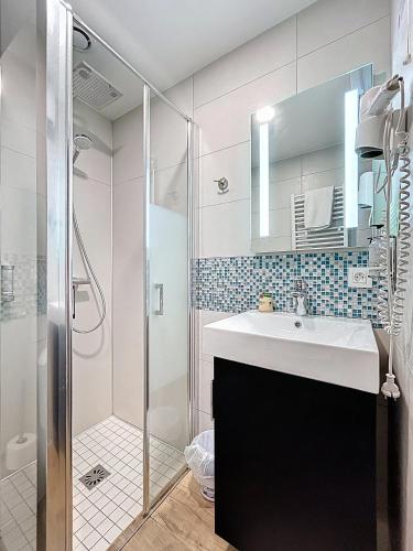 a bathroom with a sink and a shower at Hôtel Lacour in Eygliers