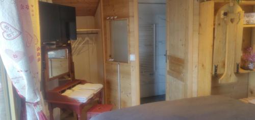 a room with a desk and a television in a room at Le nid bucolique in Publier