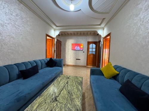 a living room with a blue couch and a table at Larache City Apartment in Larache