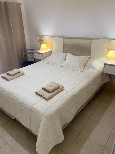 a large white bed with two towels on it at Heart Viedma in Viedma