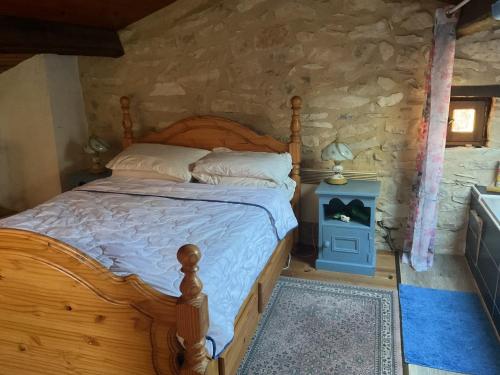 a bedroom with a bed and a stone wall at Les Mialles in Prayssac