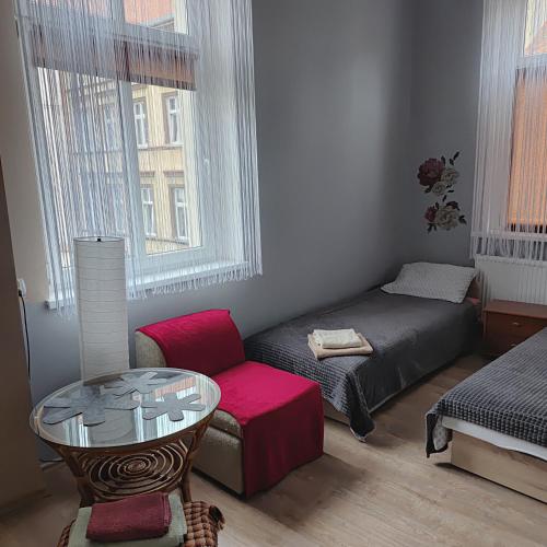 a living room with a bed and a table at Hostel Staromiejski in Grudziądz