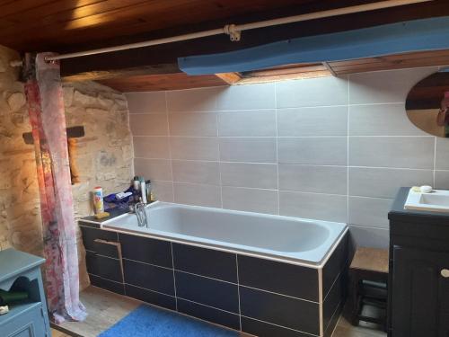 a bathroom with a bath tub in a room at Les Mialles in Prayssac