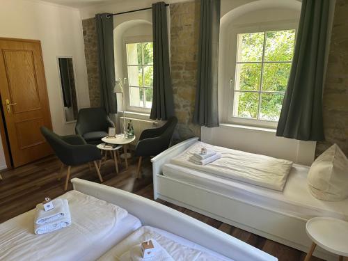 a hotel room with two beds and a table and chairs at Hotel Hohe Reuth in Bocka