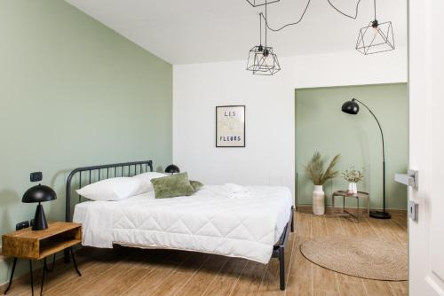 a bedroom with a bed with white sheets and green walls at Dimore Abruzzo - Borgo 27 in Celano