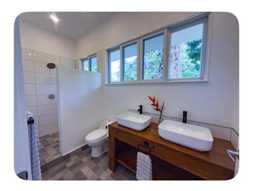a bathroom with two sinks and a toilet at Spot on Drago in Bocas Town