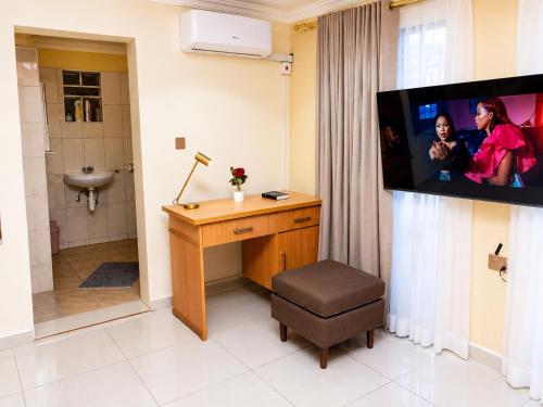 a bathroom with a desk and a tv on a wall at JAC Tilama BNB Villa-3 Bedroom in Blantyre