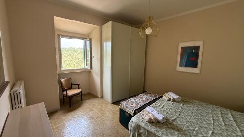 a bedroom with two beds and a chair and a window at Casina Da Vinci in Vinci
