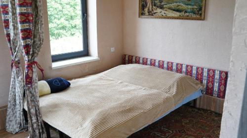 a small bed in a room with a window at Jermuk gaden in Kechʼut