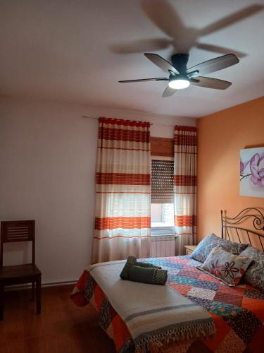 a bedroom with a bed and a ceiling fan at Casa rural el cerrete in Riópar