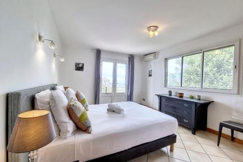 a bedroom with a bed with a table and a window at Villa Perle de lOcéan Piscine - Clim in Les Avirons