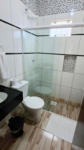 a bathroom with a toilet and a sink at Pousada Central Parque in Penha