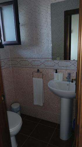 a bathroom with a sink and a toilet and a mirror at La Quimera in El Ronquillo