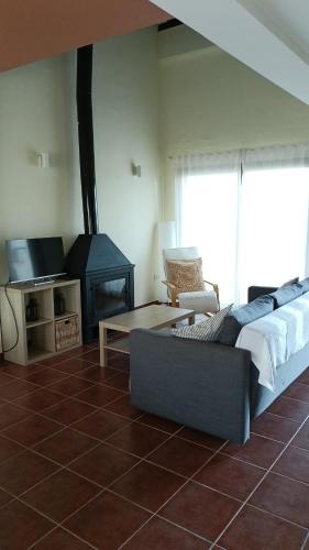a living room with a bed and a fireplace at La Quimera in El Ronquillo