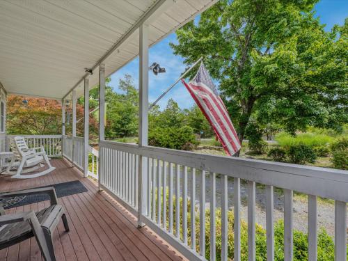 a porch with an american flag on it at Blue Badger Cottage -Wifi, Fire Pit, Fireplace, Screen Porch, Game Room, King Bed, Grill in Morton Grove