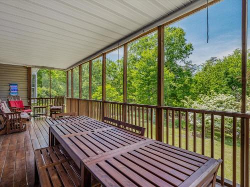 a screened in porch with a wooden table and chairs at Blue Badger Cottage -Wifi, Fire Pit, Fireplace, Screen Porch, Game Room, King Bed, Grill in Morton Grove