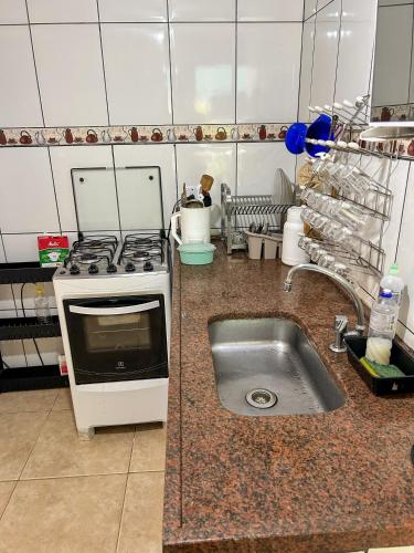 a kitchen with a sink and a stove at Chale do Índio - Ilha Grande in Angra dos Reis