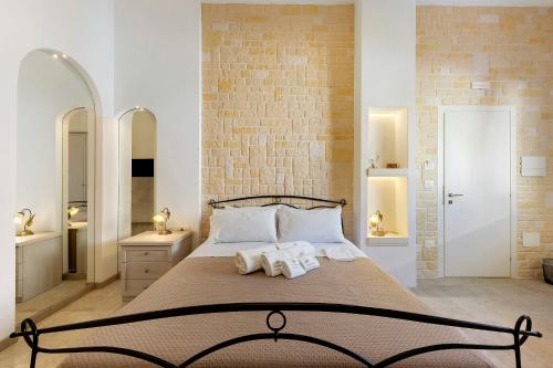 a bedroom with a large bed with two towels at L'Aurora Bed and Breakfast in Ugento