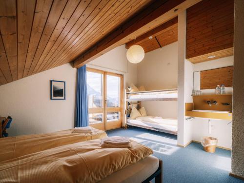 a bedroom with two beds and a bunk bed at Haslibergoase in Hasliberg