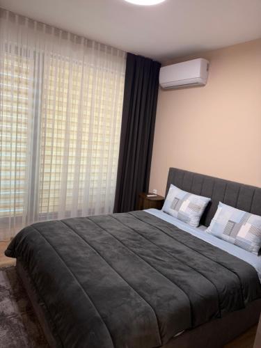a bedroom with a large bed in front of a window at Resident park apartment in Plovdiv