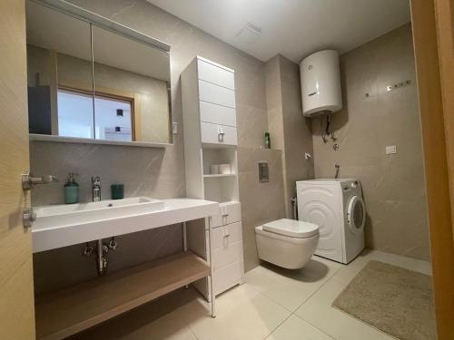 a bathroom with a sink and a washing machine at River side 18 in Herceg-Novi