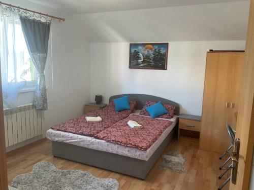 a bedroom with a large bed with blue pillows at Homestay Renata in Nová Lesná