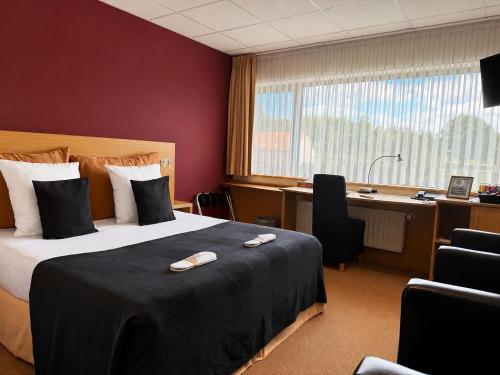 a hotel room with a bed and a desk at Axis Hotel Brussels Airport in Kortenberg