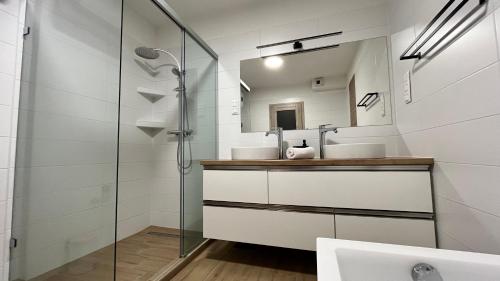 a bathroom with two sinks and a mirror at Rezidex Apartmanház in Szeged