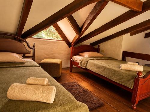 a attic room with two beds and a window at Valle Verde Lodge - Vista in Samaipata