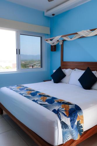 a bedroom with a large bed with blue walls at vivo resort in Chano