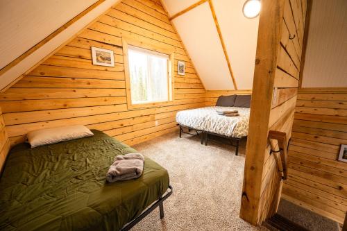 a log cabin bedroom with a bed and a window at Halibut Haven, Cabin 7 at Lower Kenai Lodge in Kenai