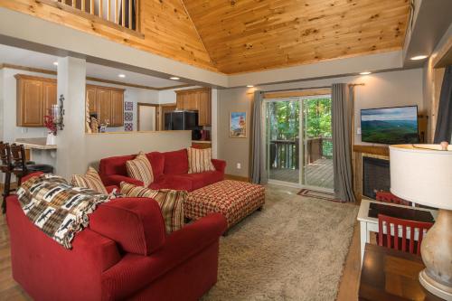 a living room with two red couches and a fireplace at Lei Lei Mountainstay in Beech Mountain
