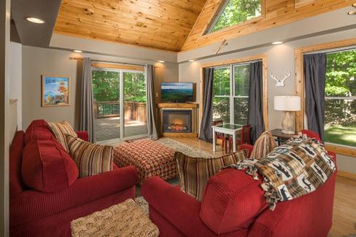 a living room with two red couches and a fireplace at Lei Lei Mountainstay in Beech Mountain