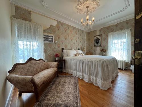 a bedroom with a bed and a chair and a chandelier at The Boho Buffalo Inn in Buffalo