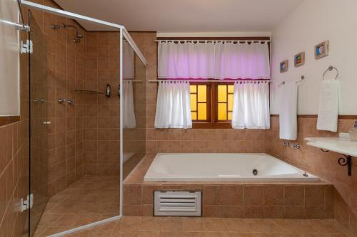 a large bathroom with a tub and a shower at Pousada das Pedras Paraty -RJ in Paraty