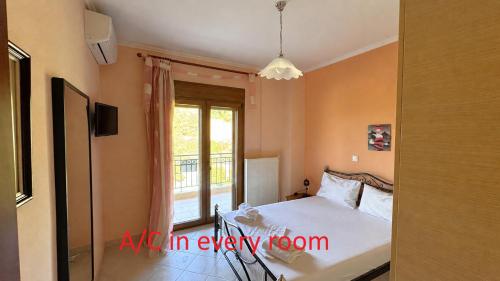 a bedroom with a bed and a window at The Emerald Garden Maisonette in Siviri