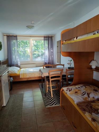 a bedroom with two bunk beds and a table and chairs at Ubytování Carmen in Česká Skalice