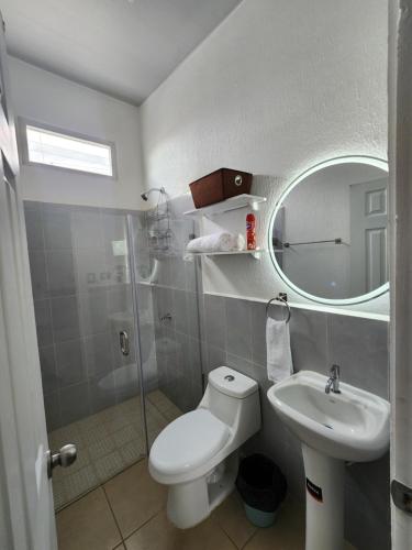 a bathroom with a toilet and a sink and a mirror at Marsella Rest House in Sitio del Niño
