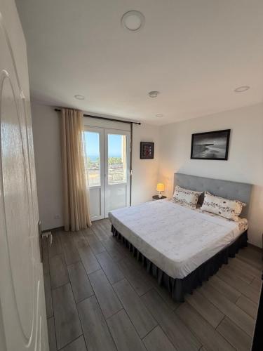a bedroom with a bed and a large window at Casa Mare Oureah in Mazagran