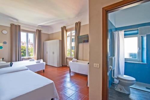 een hotelkamer met twee bedden en een badkamer bij Hotel Genesi in Florence