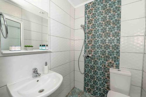 a bathroom with a toilet and a sink and a shower at Coral Guest House in Obzor